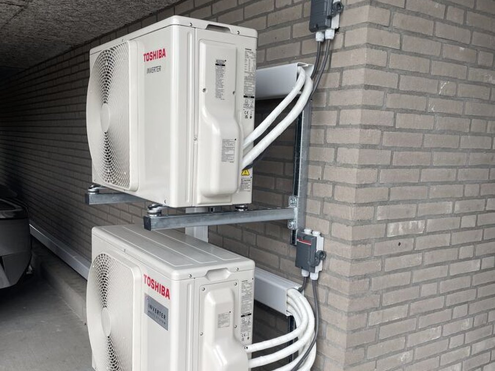 Twee Toshiba buitenunits boven elkaar gemonteerd op een wandframe