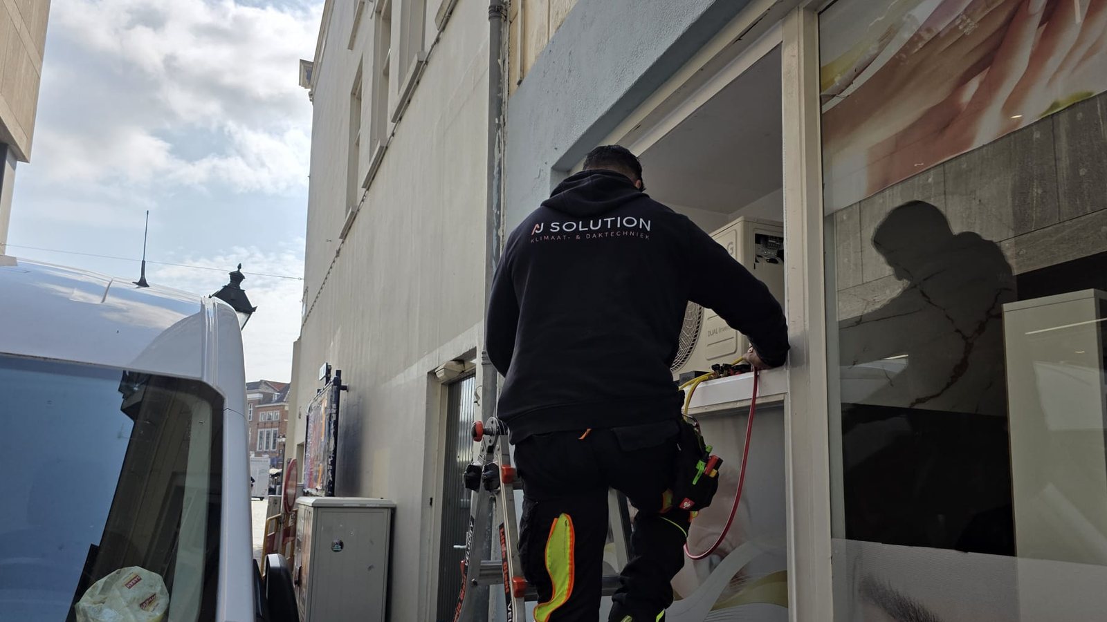 Monteur van AJ Solution aan het werk bij de bedrijfsbus
