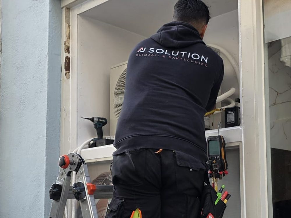 Monteur van AJ Solution monteert een aircosysteem — AJ Solution bedrijfskleding