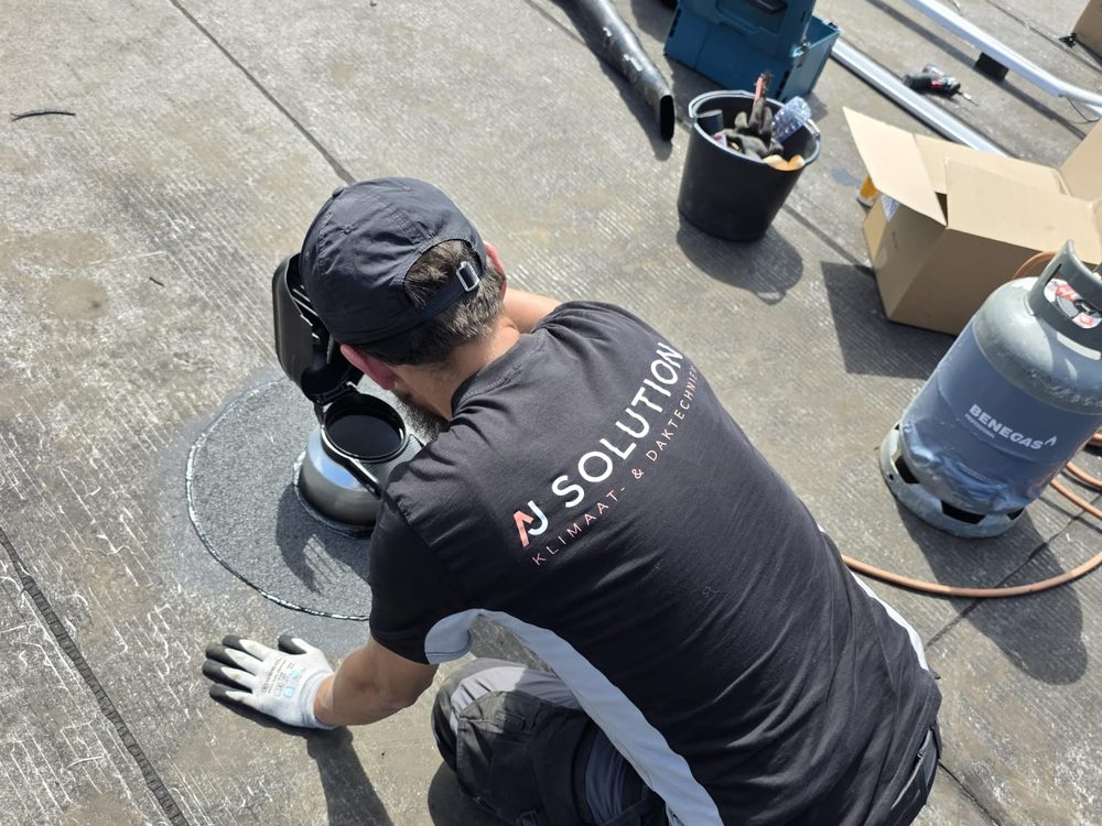 Dakspecialist van AJ Solution werkt aan een bitumen plat dak